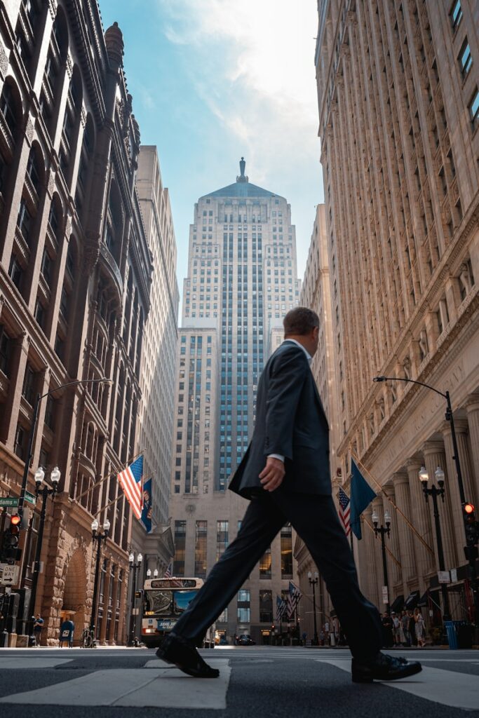 A man in a suit walking across a street